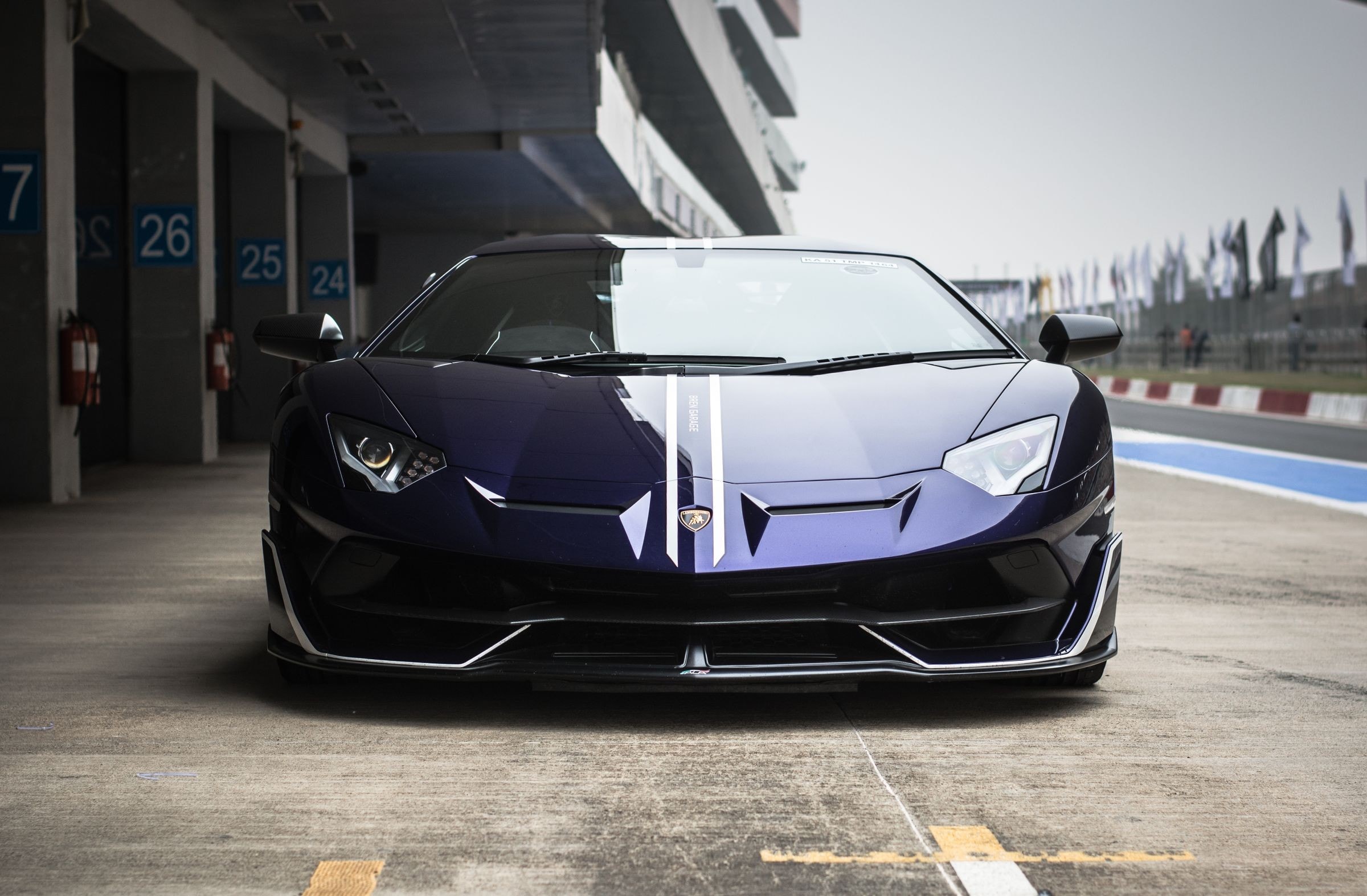 Supercar sombre sur la ligne d'un circuit, ciel bas